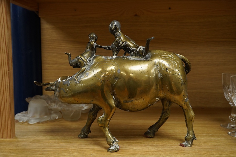 A Chinese bronze and lead model of an ox with two riders, 25cm high. Condition - fair